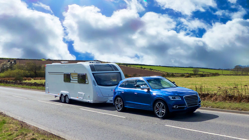 An image of a caravan being towed on a road.